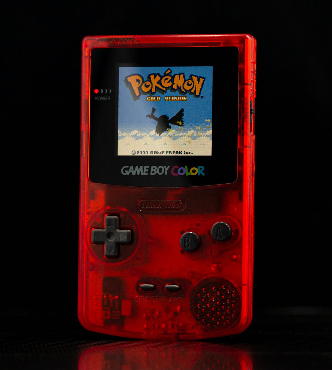 A back-lit Gameboy Color displaying Pokemon Gold
